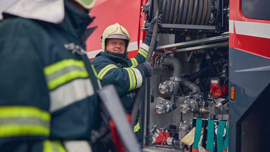 mature-firefighter-training-work-with-fire-equipment (1)